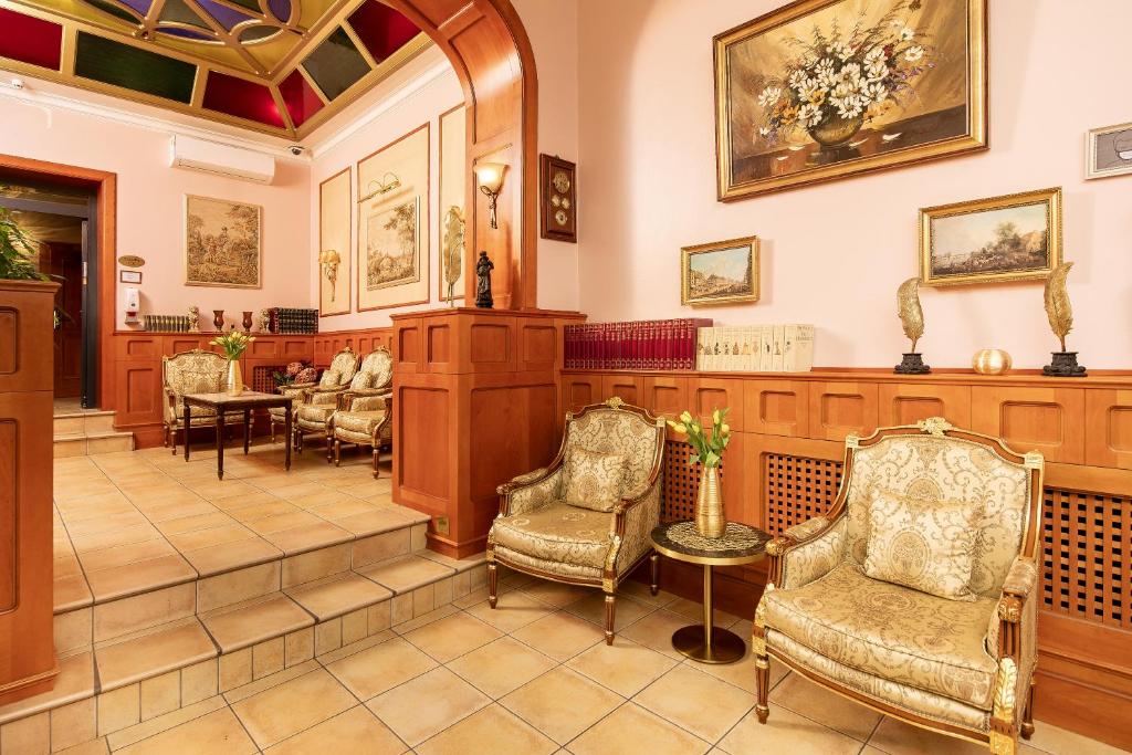 奥芬巴赫凯撒霍夫城市酒店的一间设有椅子和等候桌的等候室