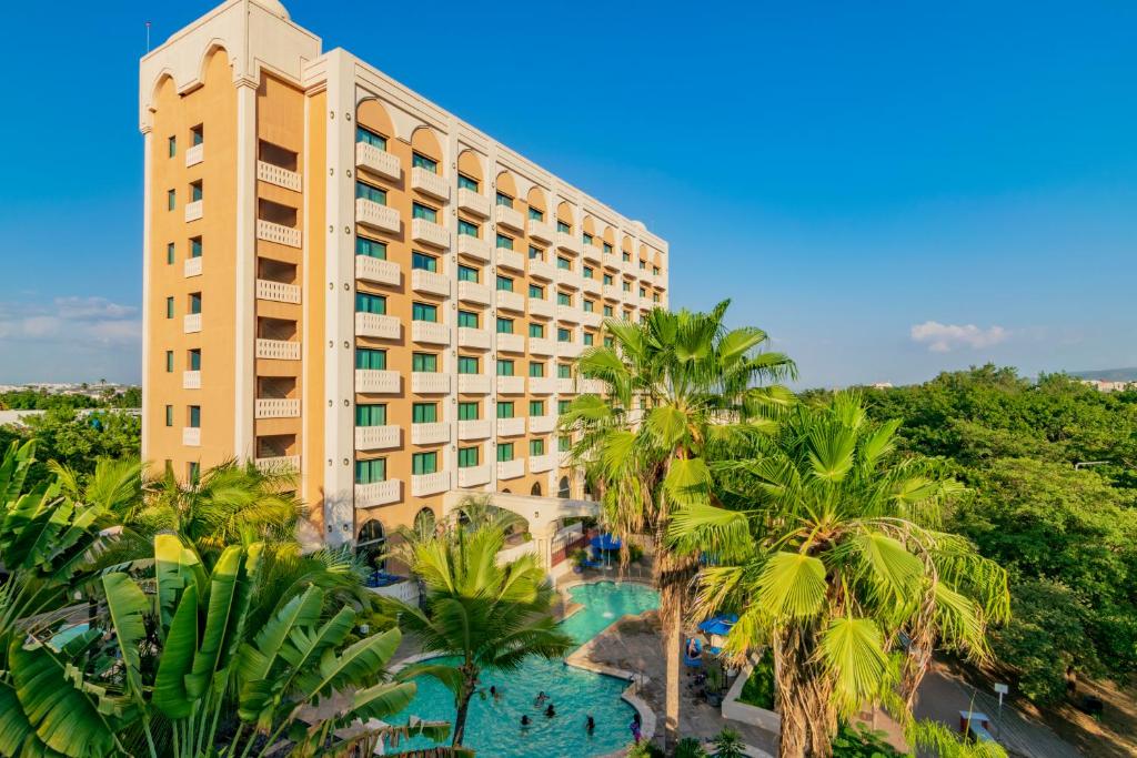 库利亚坎Hotel Lucerna Culiacan的享有度假村的空中景致,设有游泳池和棕榈树