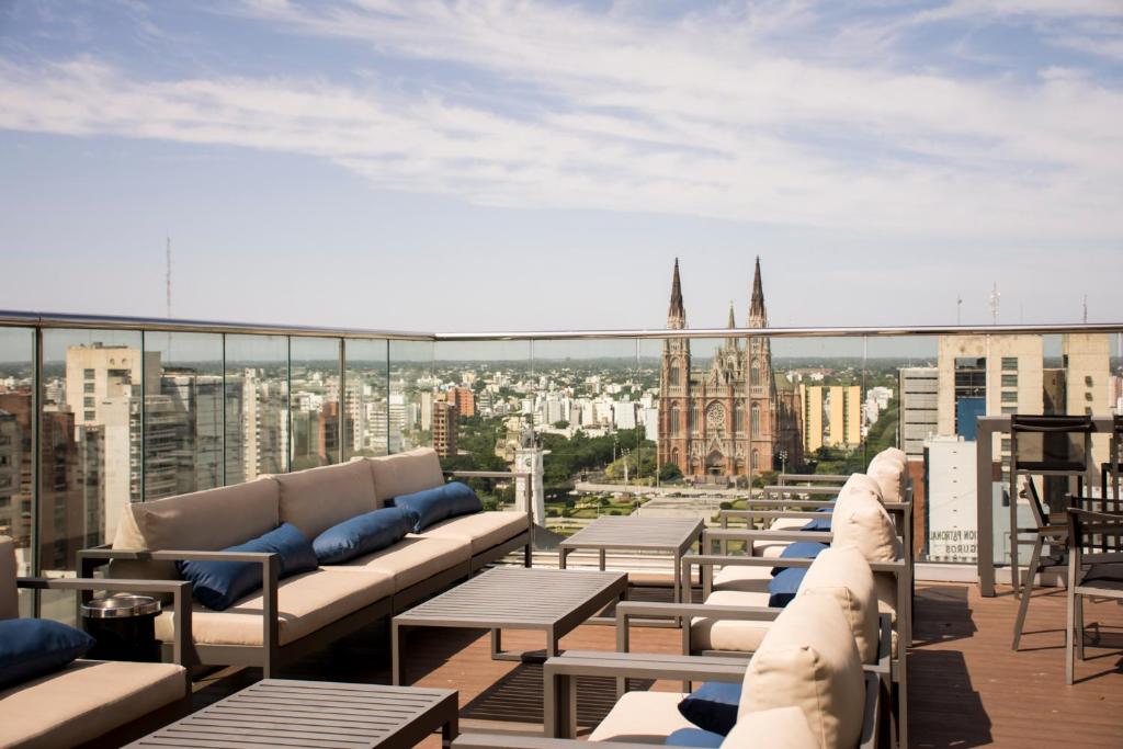 拉普拉塔Grand Brizo La Plata的阳台设有沙发和桌子,享有城市美景。