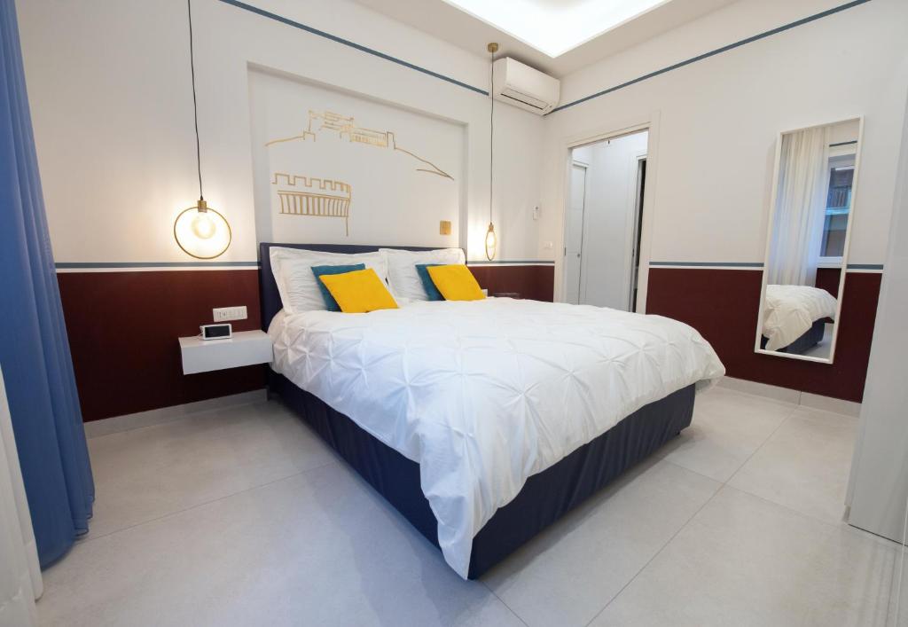 那不勒斯Napoli City Center - Appartamenti e Camere的一间卧室配有一张大床和两张黄色枕头