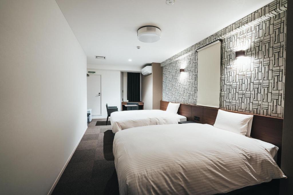 佐贺市TAPSTAY HOTEL - Vacation STAY 35203v的酒店客房,设有两张床和镜子