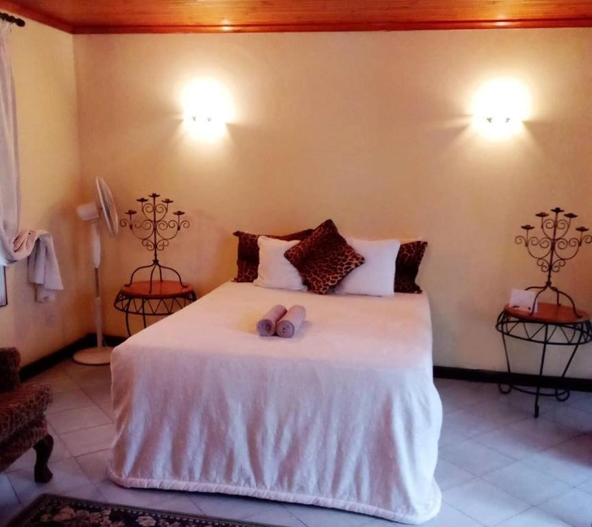恩多拉Copperbelt Executive Accommodation Ndola, Zambia的一间卧室配有一张带两张蜡烛的床。