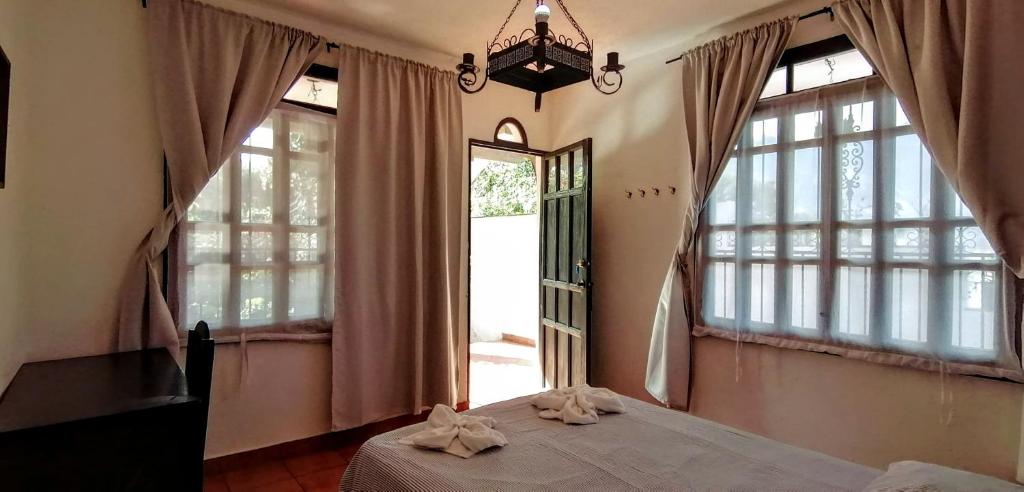 圣佩德罗拉拉古纳Mikaso Hotel的一间卧室设有一张床和一个大窗户