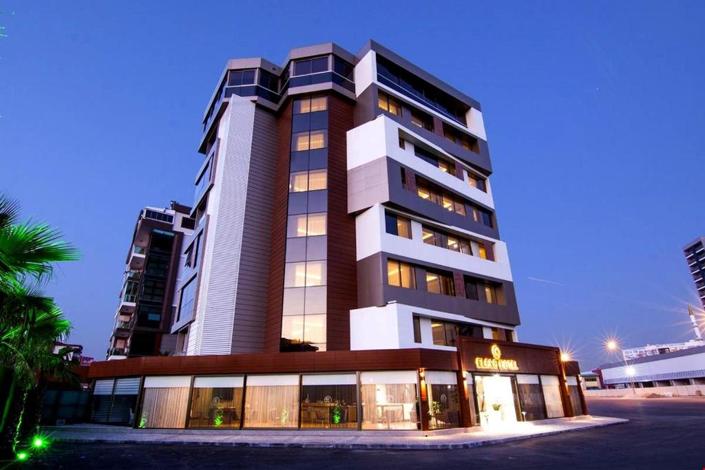 KarşıyakaMAJURA HOTEL BUSINESS的前面有一间商店的高楼