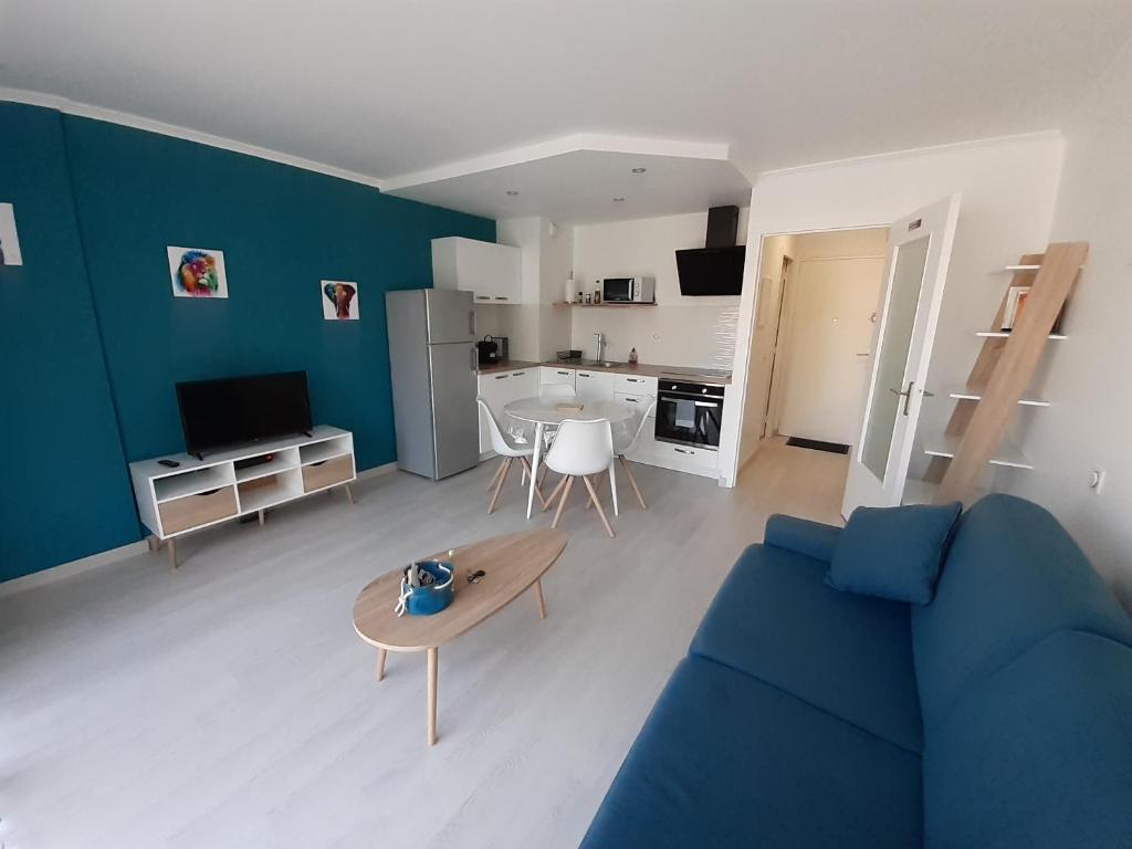 拉波勒Studio Centre - Tout Confort - Tout à pied的客厅配有蓝色的沙发和桌子
