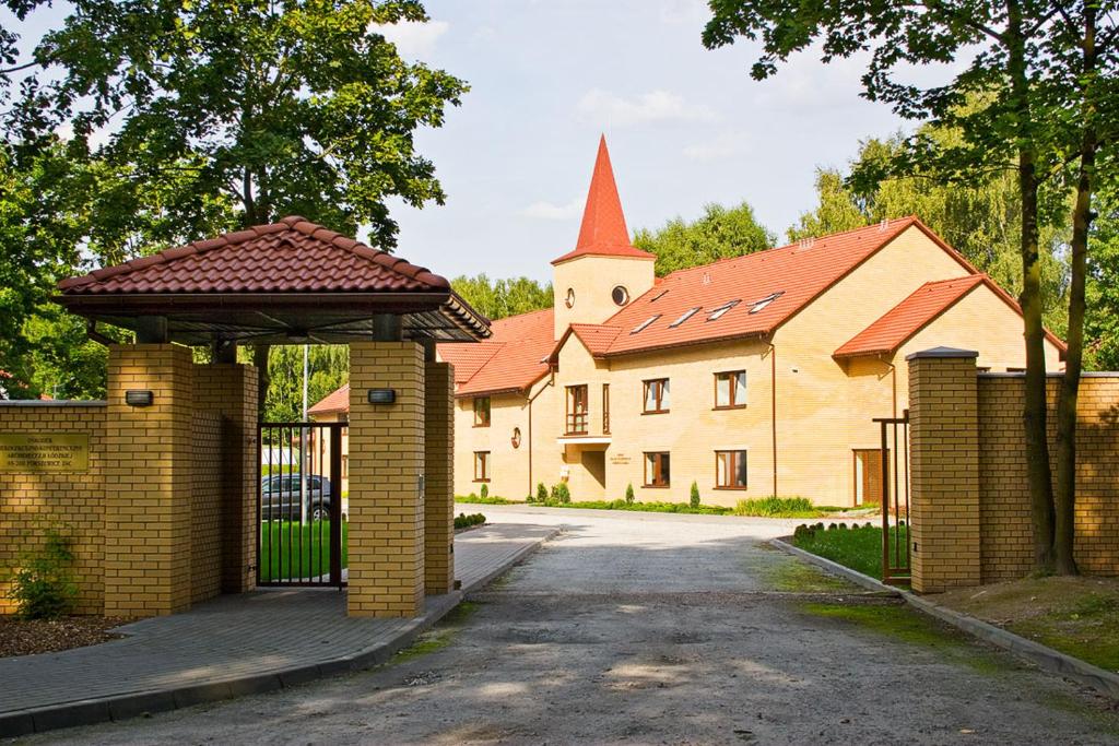 帕比亚尼采Uroczysko Porszewice - Ośrodek Konferencyjno-Rekolekcyjny Archidiecezji Łódzkiej的一座带门和教堂的建筑