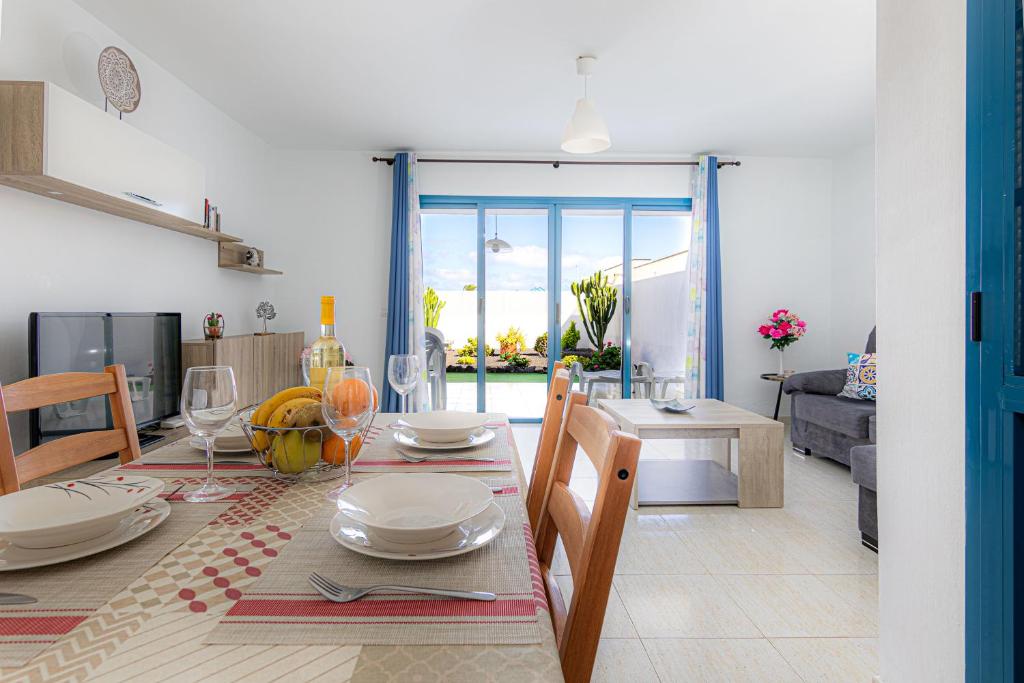 科斯塔特吉塞Apartamento Ideal Costa Teguise的用餐室以及带桌椅的起居室。