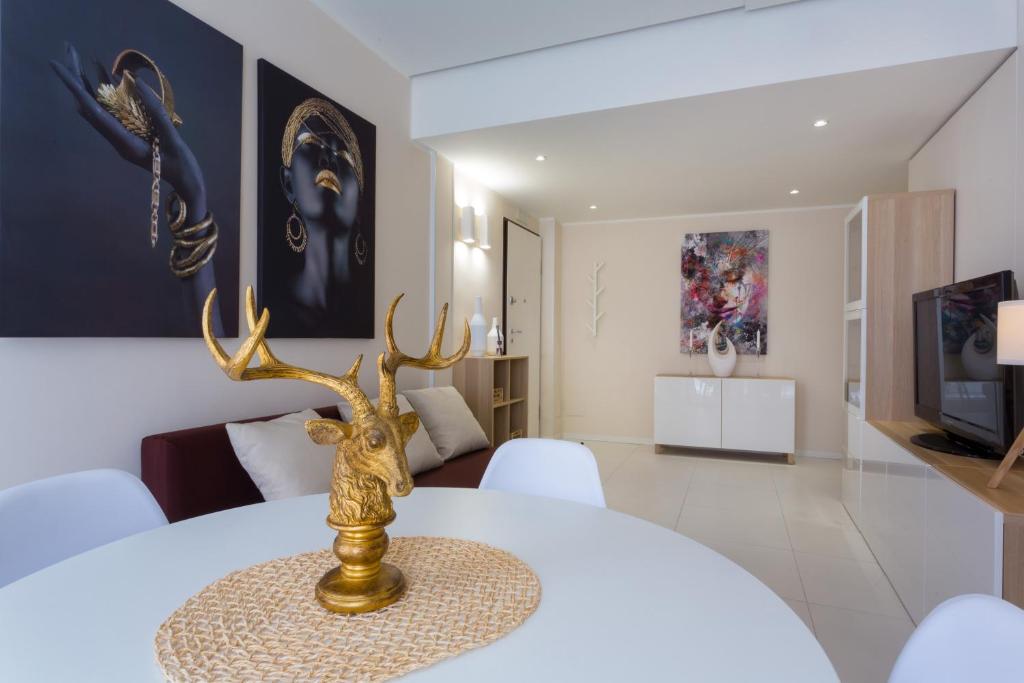 卡塔尼亚斯泰西科罗独家公寓式酒店的一间用餐室,配有一张白色桌子和鹿肉奖杯