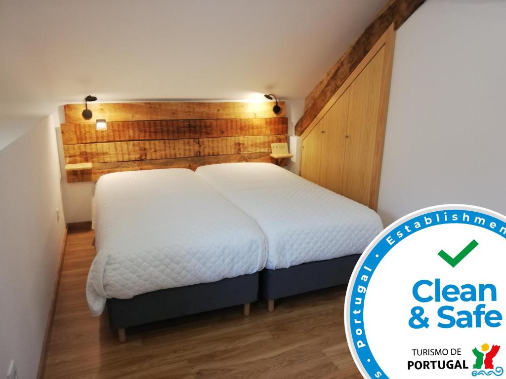 萨布盖鲁Sambuc'asa - Serra da Estrela的卧室配有白色的床和木墙