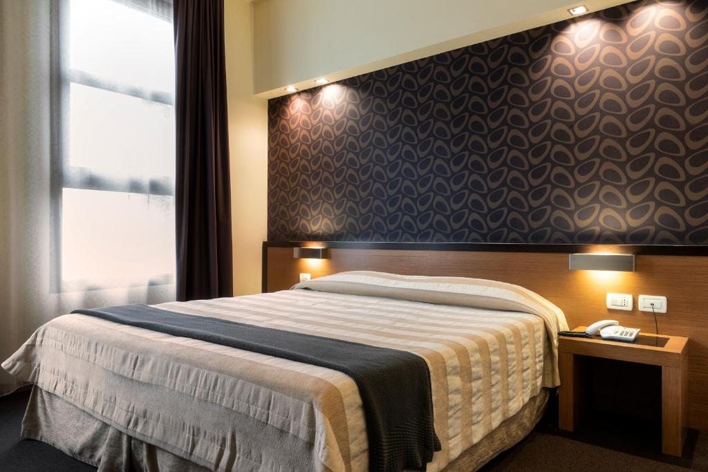 博洛尼亚HC3酒店的一间卧室设有一张大床和一个窗户。