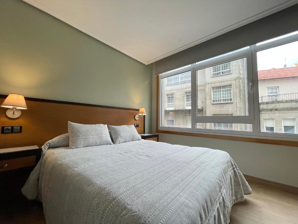 卡瓦利诺阿伦泰罗公寓酒店的一间卧室设有一张床和一个大窗户