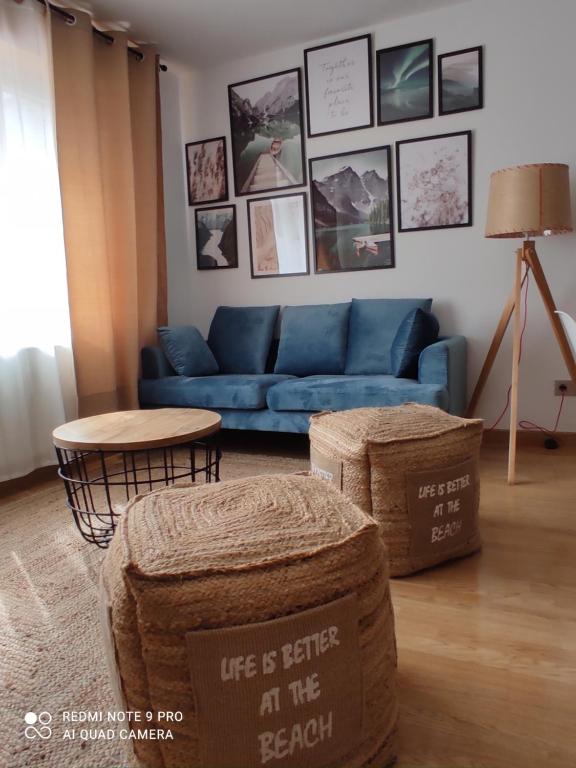 马尔皮卡Malpica Nordic Home的客厅配有蓝色的沙发和桌子