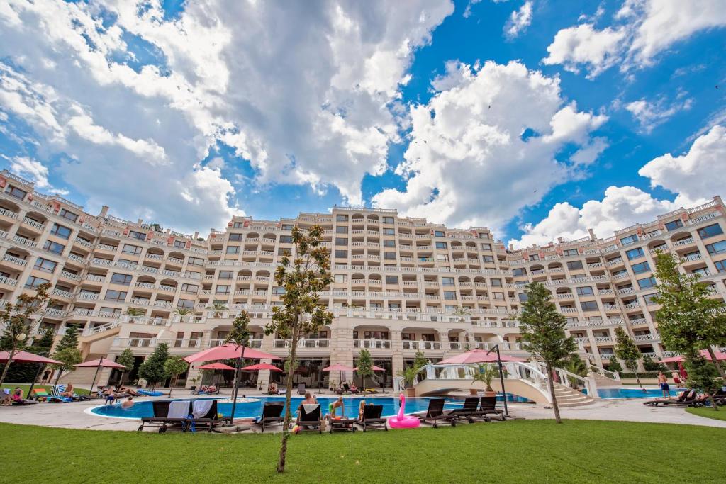 瓦尔纳Summertime in Varna South Bay Beach Residence的一座大型度假建筑,设有大型游泳池和椅子