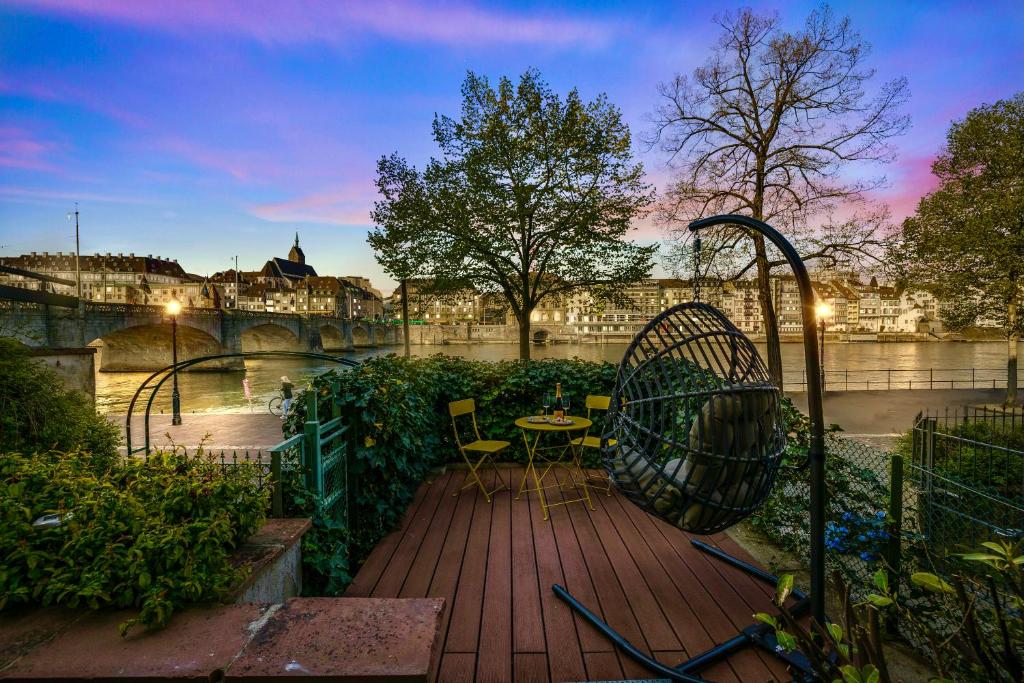 巴塞尔Stadtwohnung am Wasser I Terrasse mit Rheinblick I NETFLIX I APPLE TV的河畔的木甲板,配有桌椅