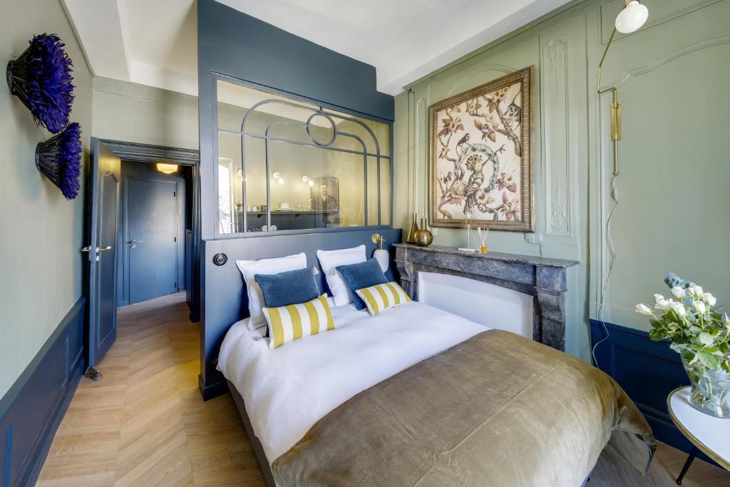 雷恩LE CELESTINE - Centre Historique -的一间卧室配有一张带蓝色墙壁的大床