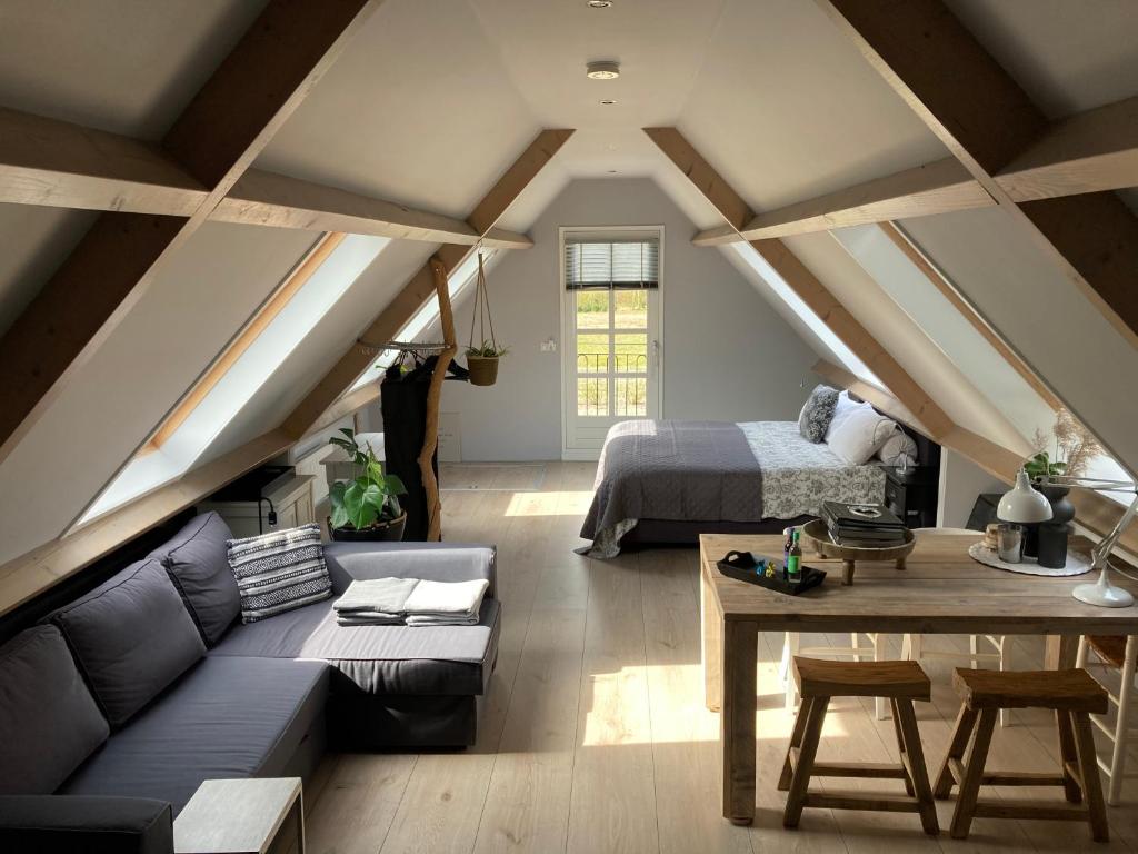 西姆斯科克BBOosterweg3 Studio的阁楼间配有床、沙发和桌子