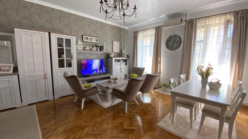 锡比乌Old Town Apartment Ana的客厅配有桌椅和电视。