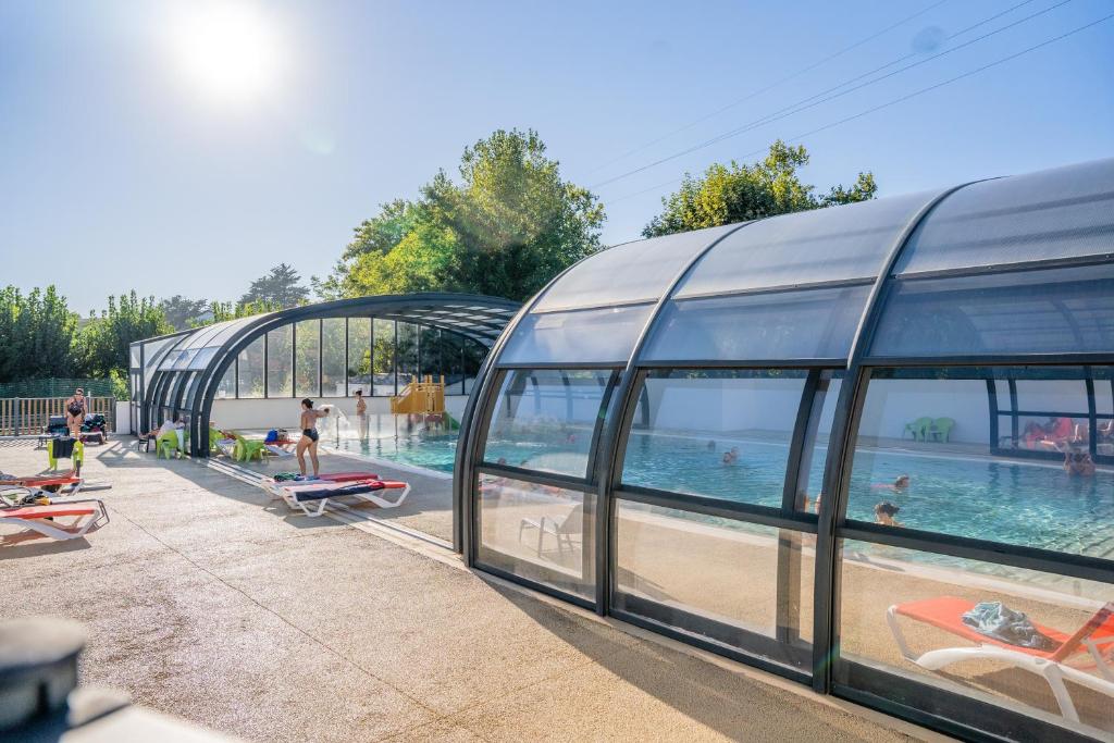 比达尔哈罗比亚露营酒店的一座玻璃建筑旁边的游泳池,里面的人