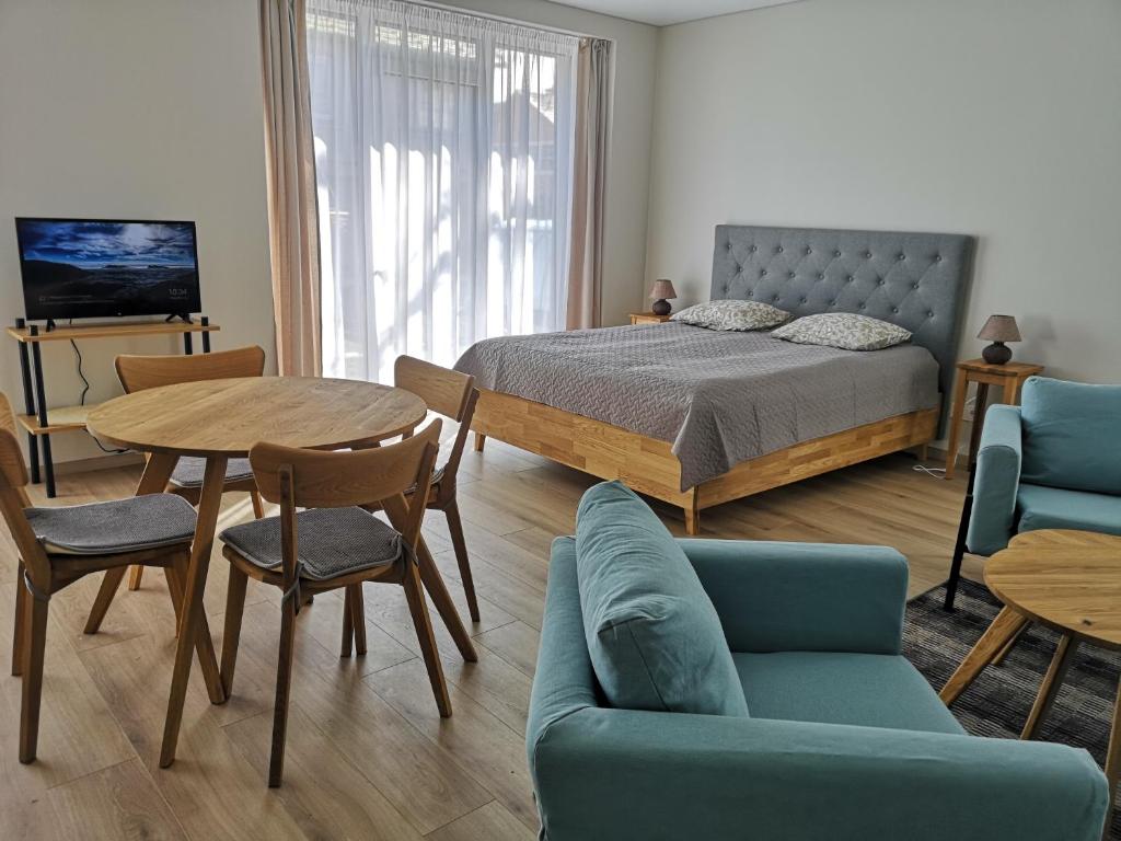 比尔什托纳斯Centro apartamentai II的卧室配有一张床和一张桌子及椅子