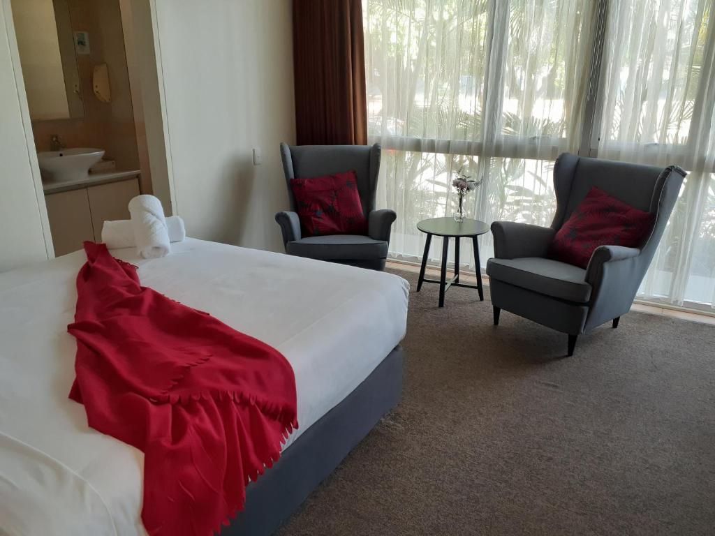 布里斯班City Star Lodge的一间卧室配有一张床、两把椅子和一张桌子