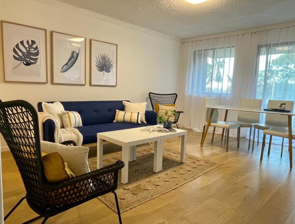 凯阿玛Kiama Palms on Collins的客厅配有蓝色的沙发和桌子