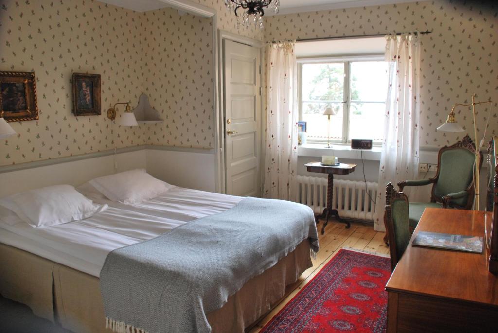 锡格蒂纳锡格蒂纳斯蒂弗特尔森酒店与会议中心的一间卧室配有一张床、一张书桌和一个窗户。
