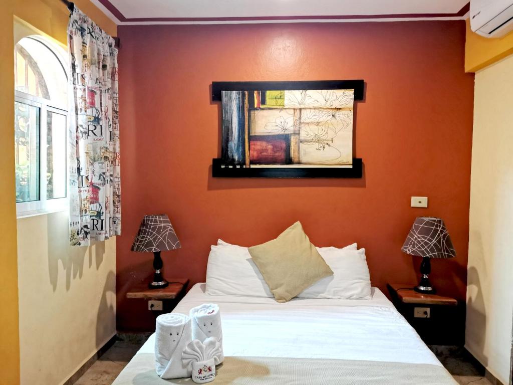 坎昆Hotel Casa Mallorca的一间卧室配有一张橙色墙壁的床