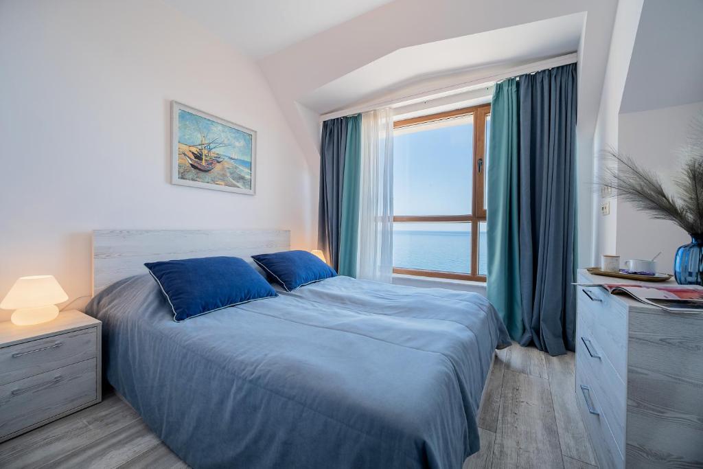 金沙Dreams in La Mer的一间卧室设有蓝色的床和窗户。