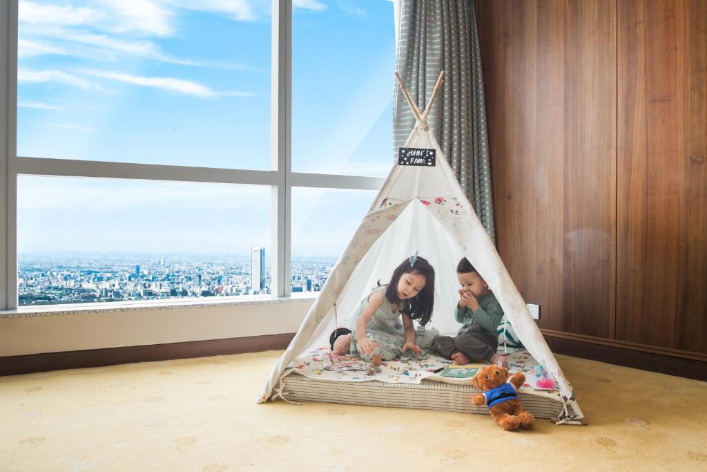 河内河内地标72洲际酒店&度假村的两个孩子坐在一个窗户房间里帐篷里