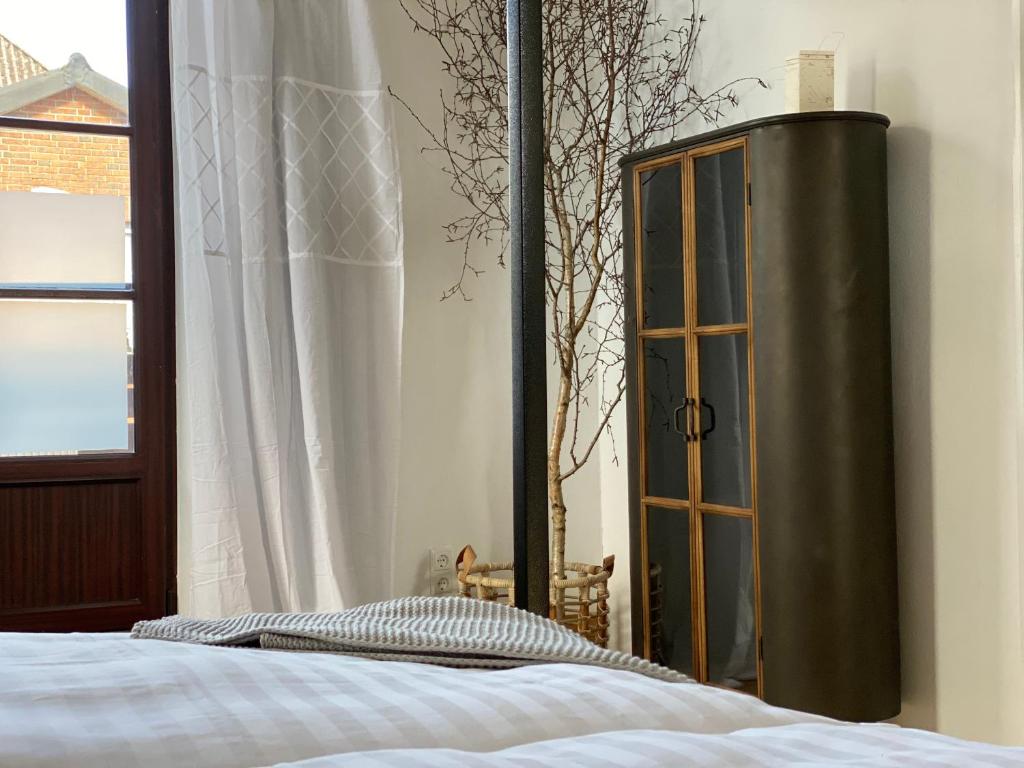 滕宁Smukkegård - historisch Wohnen im modernen Ambiente的一间卧室配有床、橱柜和窗户