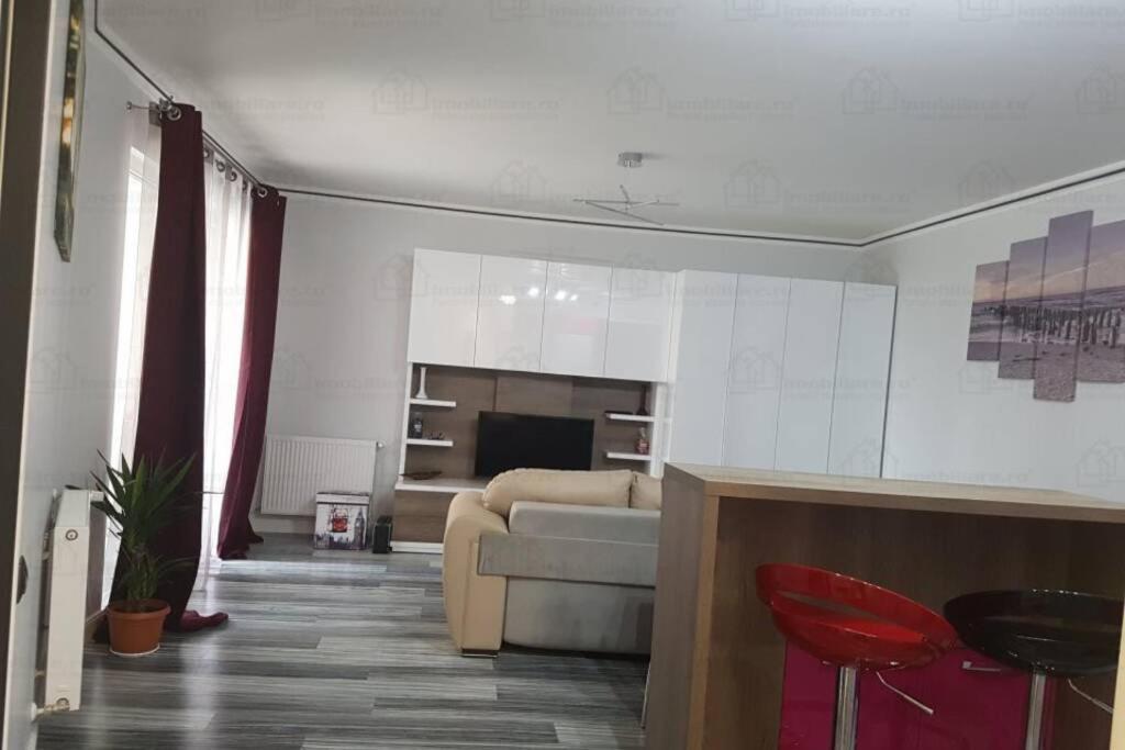 克卢日-纳波卡Central luxury apartment in Platinia Residence的带沙发和红色椅子的客厅