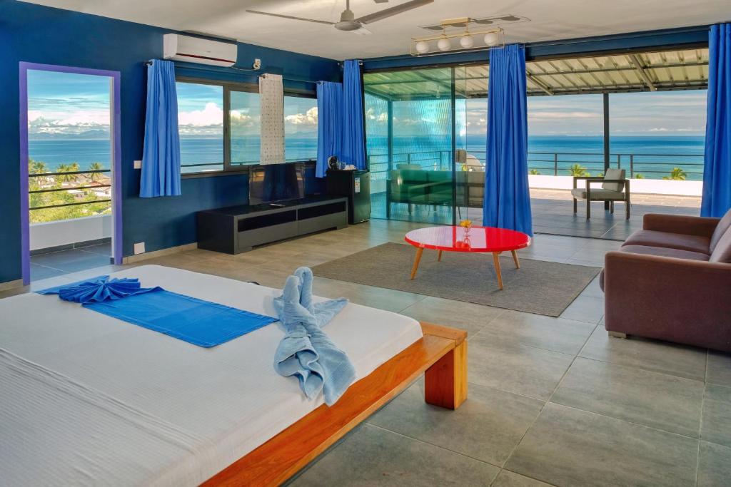 阿姆巴托洛阿卡Hôtel Villa Les Orchidées的一间卧室配有一张床,享有海景