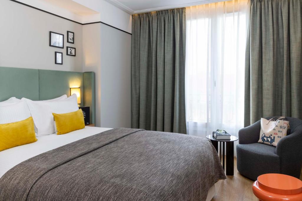 塞纳河畔讷伊Hotel Le 37 Bis的配有一张床和一把椅子的酒店客房