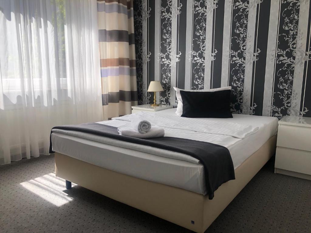 美茵河畔哈瑙皇家汉诺酒店的一间卧室配有一张大床,配有黑白壁纸