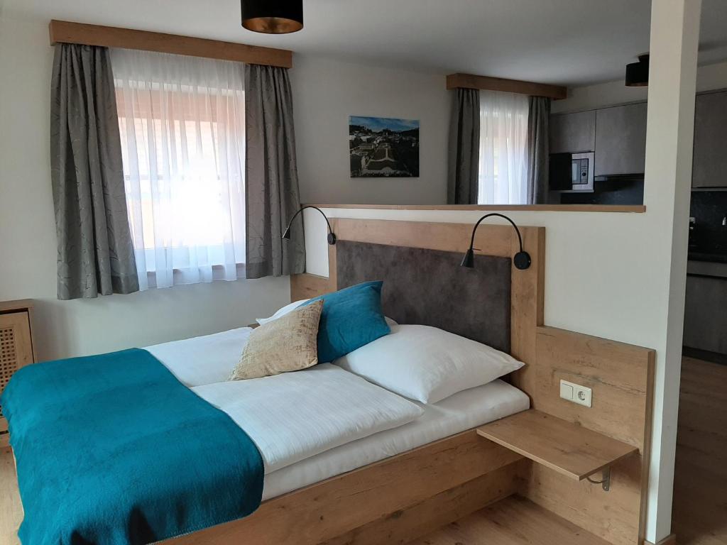 萨尔茨堡Apartments by Pension Ballwein的一间卧室配有一张带蓝色毯子的床
