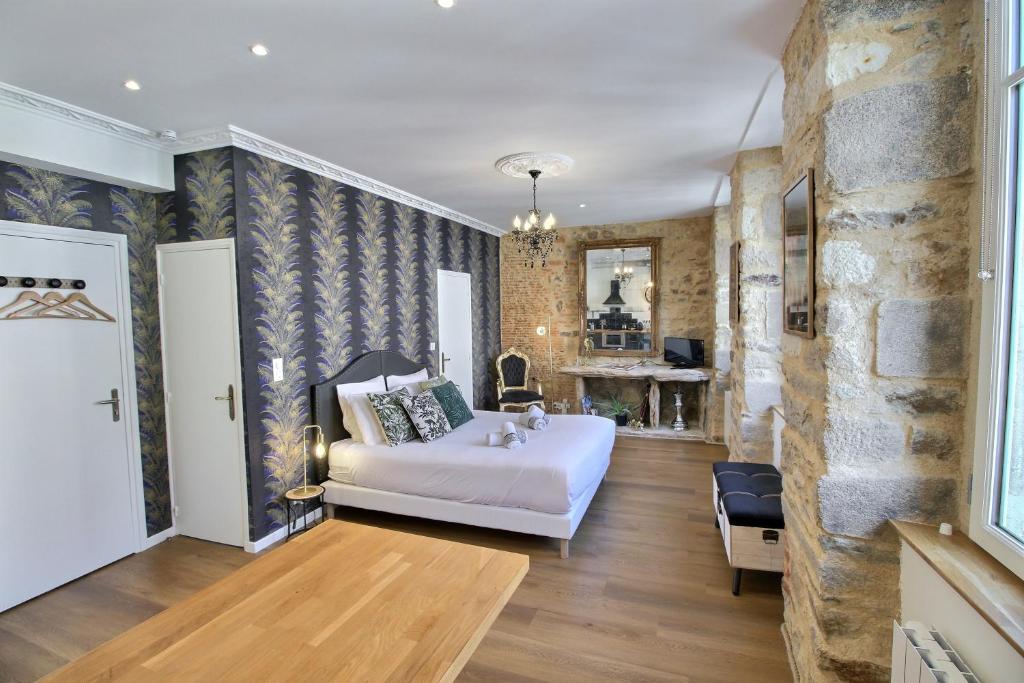 瓦讷Appartement centre-ville CHIC的卧室配有白色的床和石墙