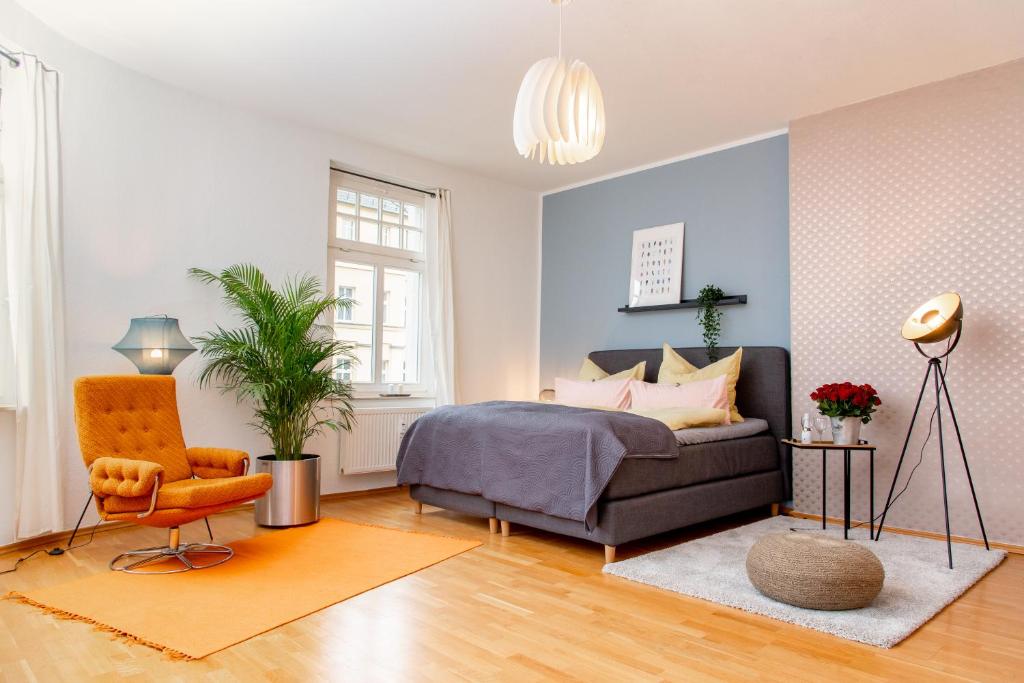开姆尼茨Kaßberg Apartment im Retro-Stil / Netflix & WIFI的一间卧室配有一张床、一把椅子和一张沙发