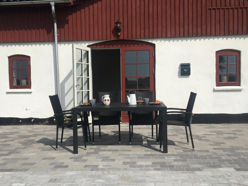 维比Vita og Pouls Gård - Guesthouse的大楼前的一张黑桌子和椅子