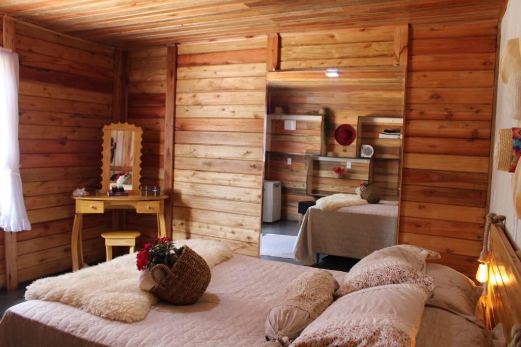 Muniz FreireBangalô-Nosso Escritorio-Hospedagem Rural的一间带两张床铺的卧室,位于带木墙的房间内