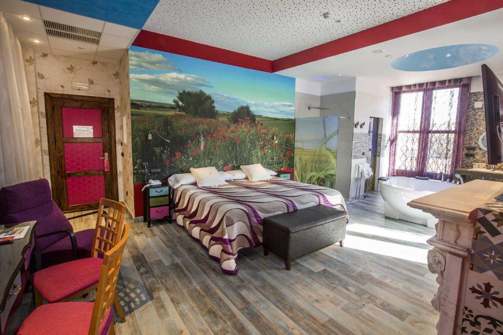La Vid y BarriosHotel SPA El Lagar de Isilla的一间卧室配有一张床,浴室设有浴缸