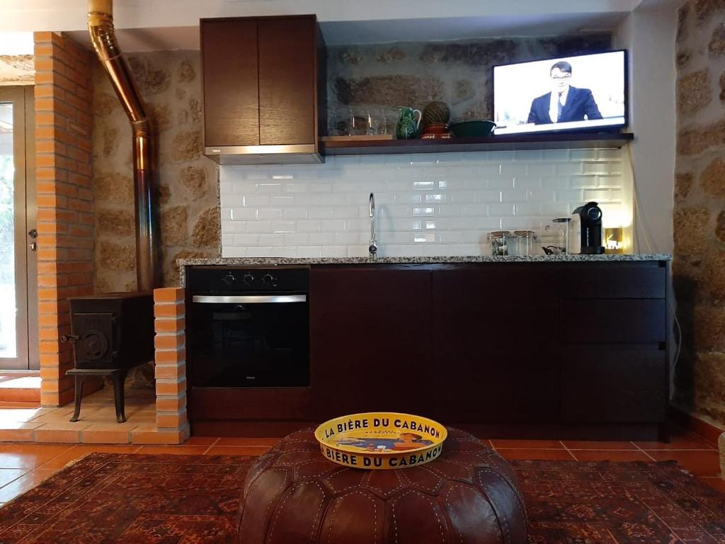 戈韦阿Anibals Boutique Lodging - Serra da Estrela的一间带炉灶的厨房和一台墙上的电视