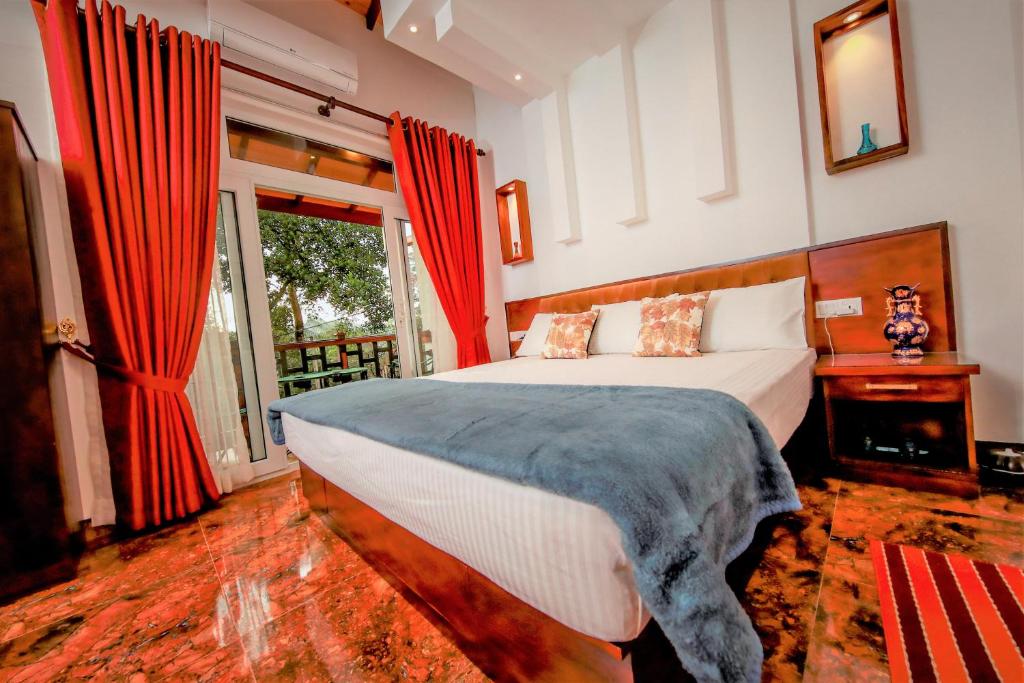 康提Y&Y Residence的一间卧室配有一张带红色窗帘的床和一扇窗户