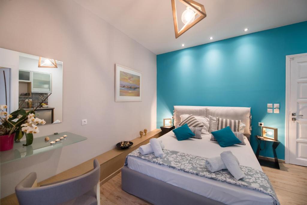 雷夫卡达镇LEFKAS CITY APARTMENTS & Suites的一间卧室设有蓝色的墙壁和一张带蓝色枕头的床。