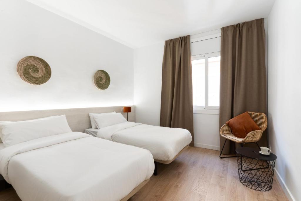 罗列特海岸Apartamentos Venecia的酒店客房设有两张床和窗户。