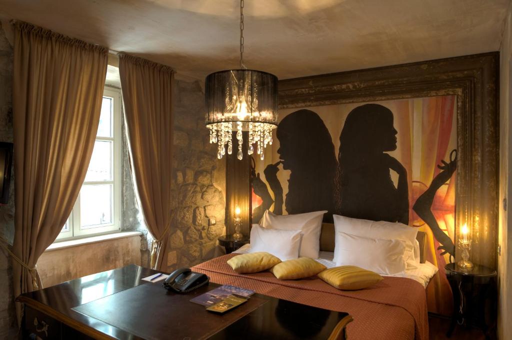 科托尔阿斯图里亚精品酒店的一间卧室配有一张壁画床