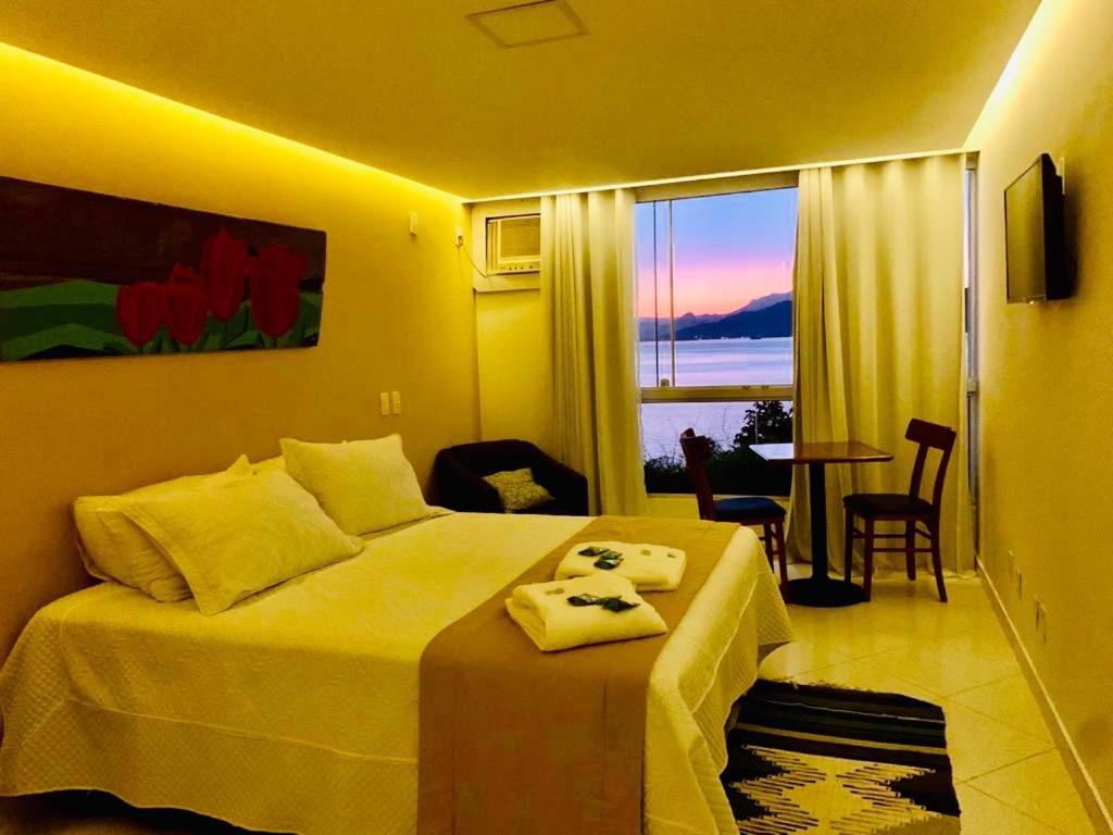 安格拉杜斯雷斯Pousada Costão do Sol的酒店客房设有一张床,享有海景。