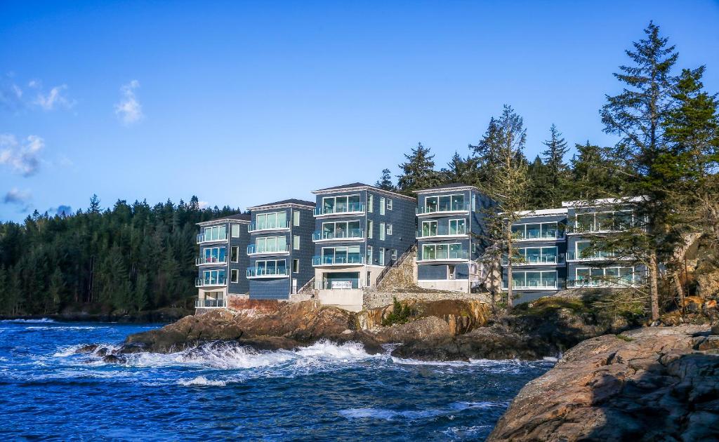 苏克SookePoint Ocean Cottage Resort的悬崖上靠近水体的建筑物