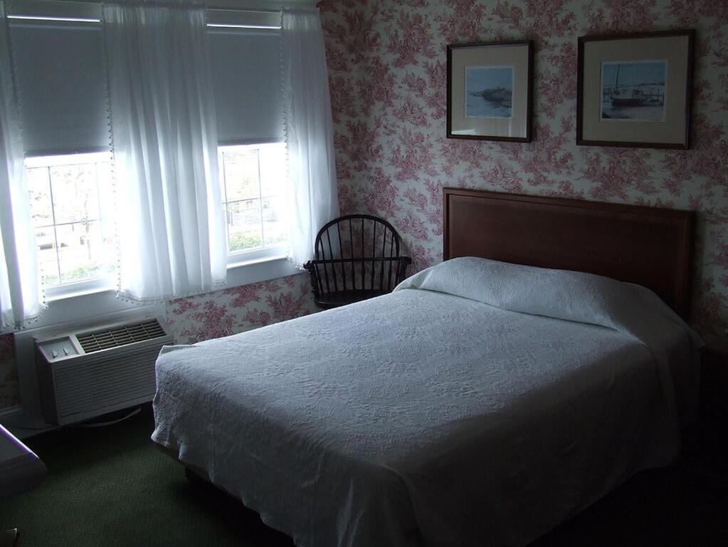 大洋城Atlantic Hotel, Inc的一间卧室设有一张床和两个窗户。