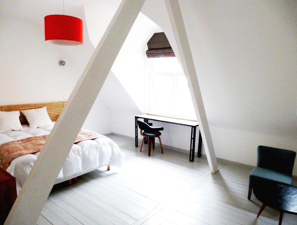 里尔里尔大道酒店的一间卧室配有一张床、一张书桌和一个窗户。