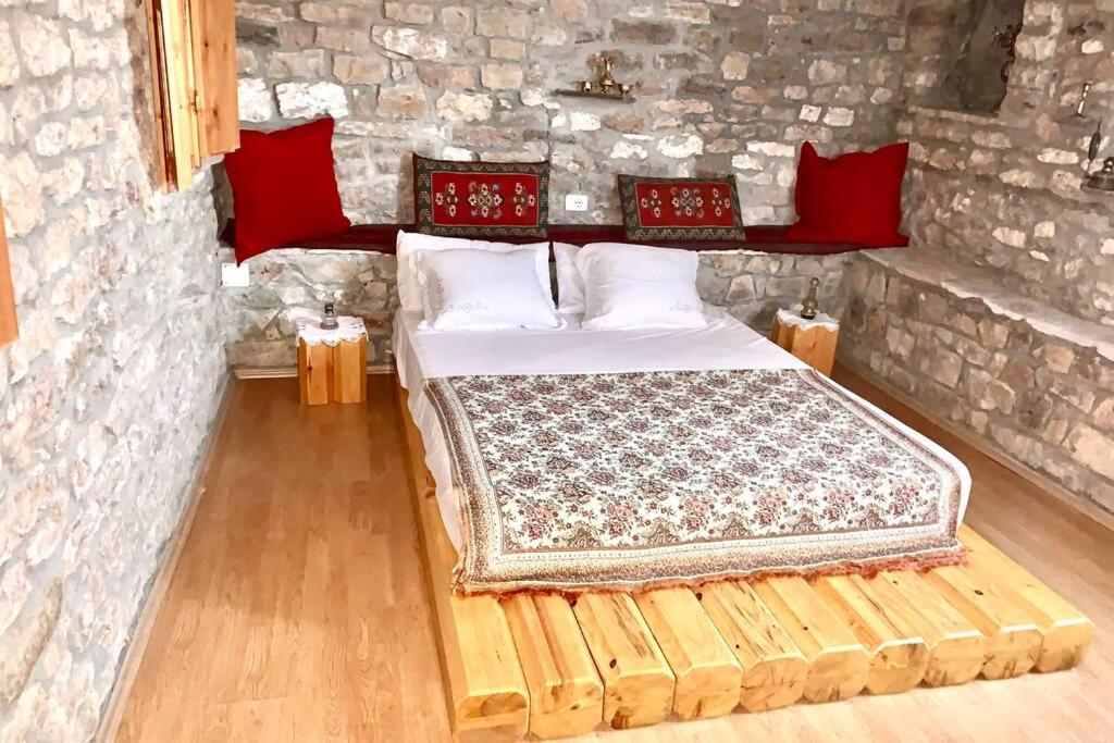 吉诺卡斯特Kubeja Guest House的卧室配有一张石墙床
